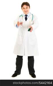 Smiling medical doctor holding pack of pills and glass of water in hands isolated on white&#xA;