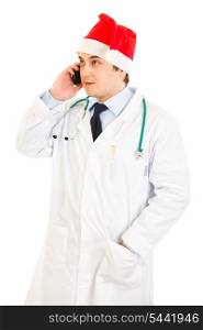 Smiling medical doctor in hat of Santa Claus talking on mobile phone isolated on white&#xA;