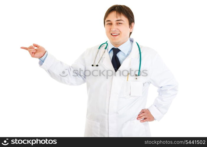 Smiling medical doctor pointing finger at something isolated on white&#xA;