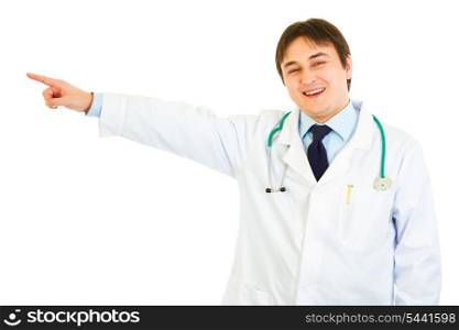 Smiling medical doctor pointing finger in corner at copy space isolated on white&#xA;