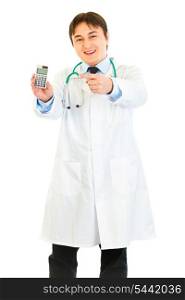 Smiling medical doctor pointing finger on calculator isolated on white&#xA;