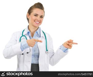 Smiling medical doctor woman pointing on copy space