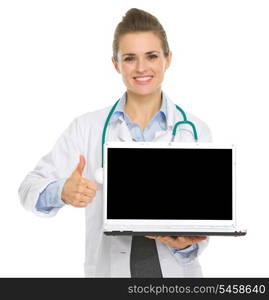 Smiling medical doctor woman showing laptop and thumbs up