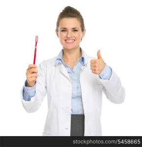 Smiling medical doctor woman showing toothbrush and thumbs up