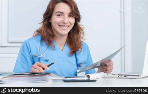 smiling medical woman doctor looking at scan image