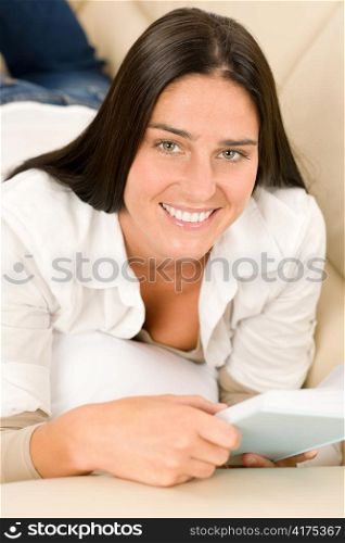 Smiling mid-aged woman read book on sofa in lounge