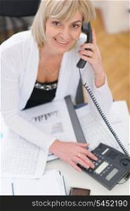 Smiling middle age business woman making phone call