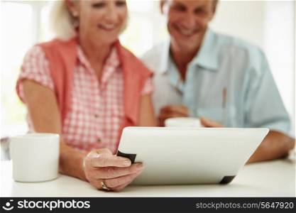 Smiling Middle Aged Couple Looking At Digital Tablet