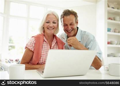 Smiling Middle Aged Couple Looking At Laptop