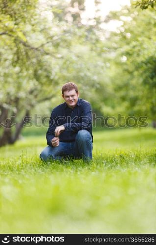 Smiling middle-aged man resting in the city park. Beautiful bokeh background.