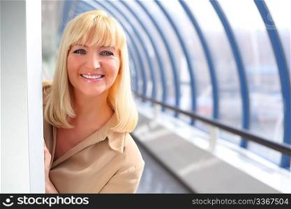 Smiling middleaged businesswoman looking from behind wall