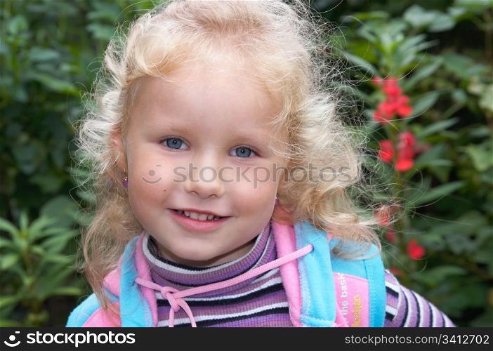 Smiling mischievous little girl in ornamental garden