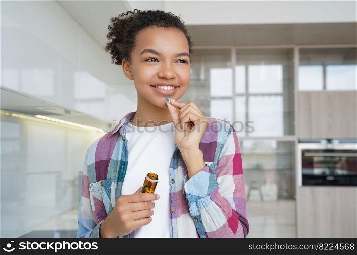 Smiling mixed race girl holding jar with pills, taking medication, vitamins pills, dietary supplement for wellness and beauty. Happy young female patient takes medicine at home. Healthy lifestyle.. Smiling young mixed race girl taking vitamins pills, dietary supplement for healthy skin and beauty
