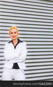 Smiling modern business woman standing at office building&#xA;