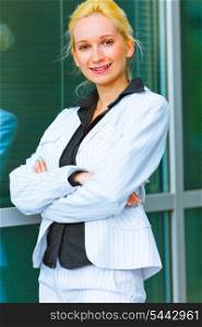 Smiling modern business woman standing near office building &#xA;