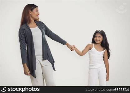 Smiling mother and daughter holding hands