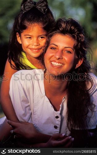 Smiling mother and daughter posing for portrait