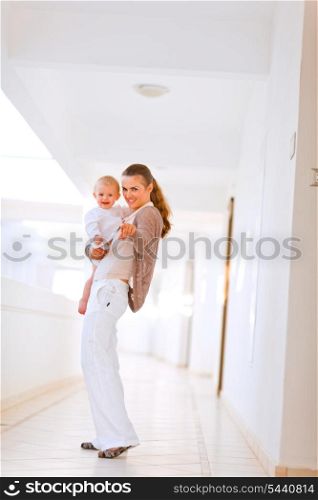 Smiling mother showing something her baby by pointing in camera&#xA;
