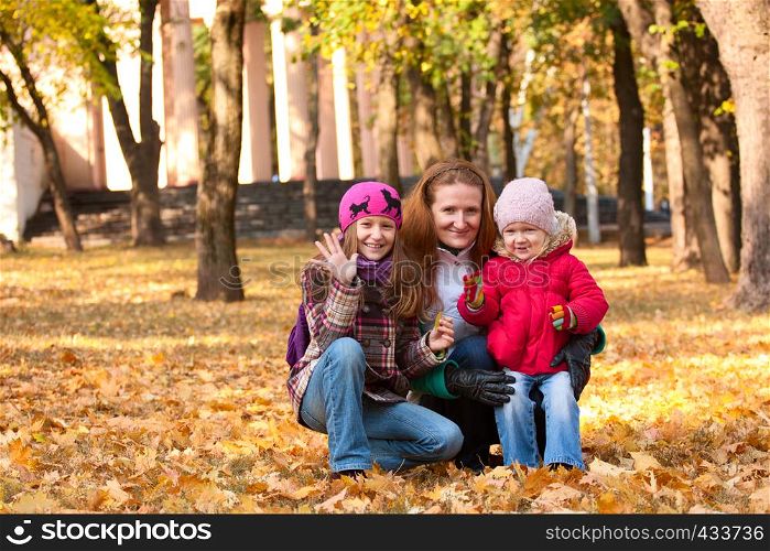 smiling mother with daughter at the autumn park