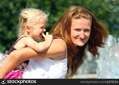 smiling mother with daughter at the cityscape outdoor