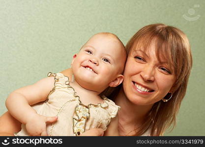 Smiling mother with the child on a green background