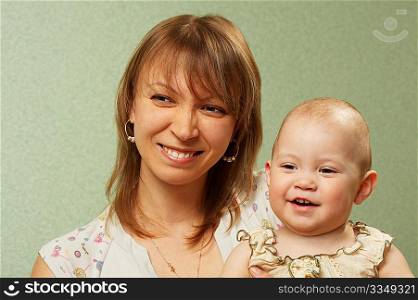 Smiling mother with the child on a green background