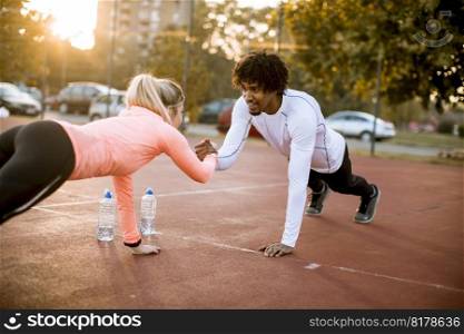 Smiling multiracial couple doing workout outdoor