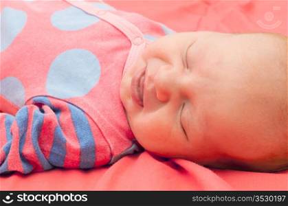 Smiling Newborn Baby Sleeping on Pink Blanket