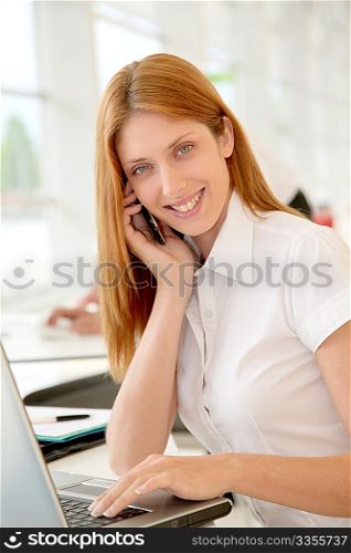 Smiling office worker in front of computer