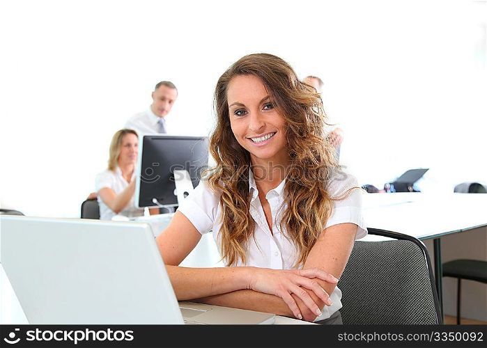 Smiling office worker in front of laptop computer