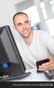 Smiling office worker sitting in front of desktop computer