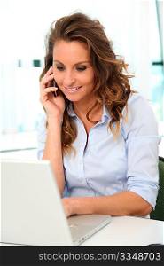 Smiling office worker talking on mobile phone