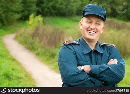 smiling officer of rescue service standing on footpath outdoors