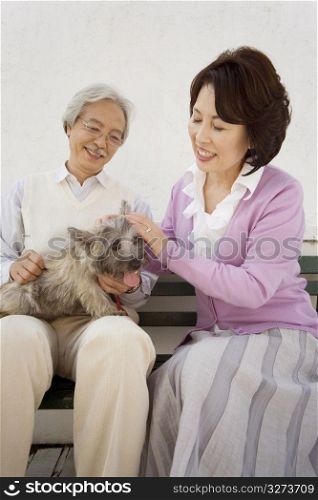 Smiling old asian couple with a dog