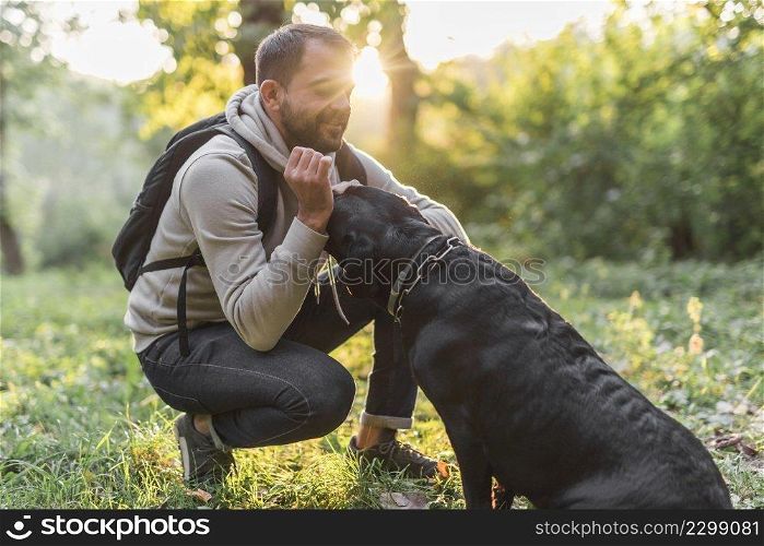 smiling owner loving his black labrador forest