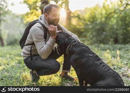smiling owner loving his black labrador forest