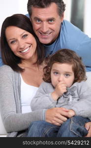 Smiling parents and their little girl