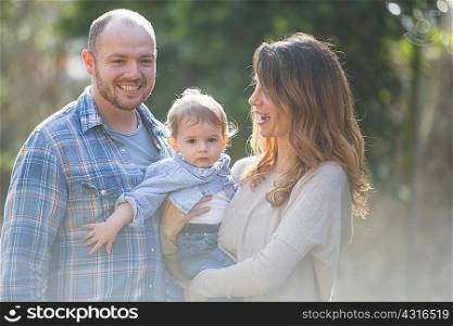Smiling parents holding baby boy