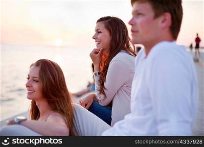 Smiling people sitting on pier outdoors
