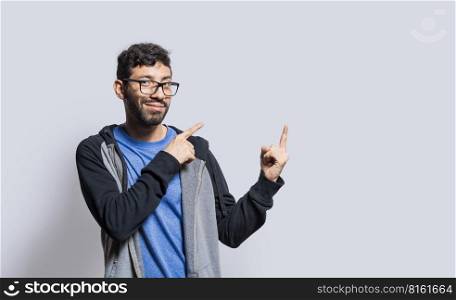 Smiling person pointing fingers to the side, smiling man recommending something with fingers on isolated background, isolated people pointing fingers at something