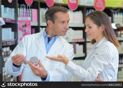 smiling pharmacist showing product to client healthcare business