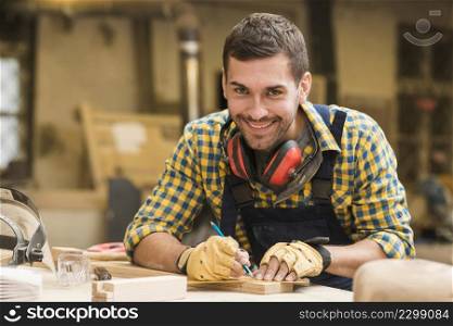 smiling portrait male carpenter taking measurement with ruler pencil wooden block