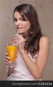 Smiling portrait of an attractive woman drinking orange juice