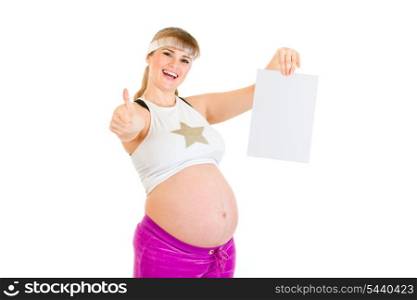 Smiling pregnant woman holding empty white paper and showing thumbs up gesture isolated on white&#xA;