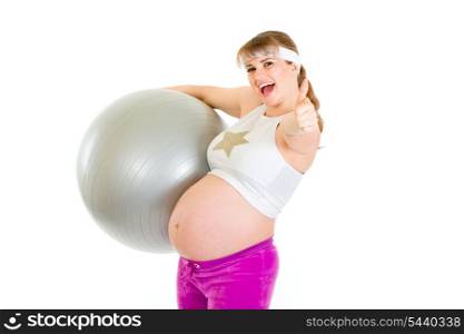 Smiling pregnant woman holding fitness ball and showing thumbs up gesture&#xA;