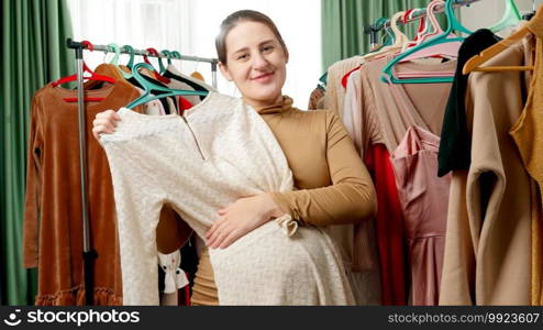 Smiling pregnant woman posing with beautiful dress for mothers and looking in camera.. Smiling pregnant woman posing with beautiful dress for mothers and looking in camera