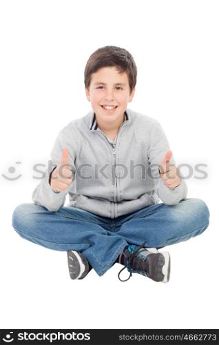 Smiling preteen boy sitting on the floor saying Ok isolated on a white background