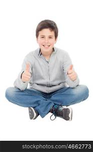Smiling preteen boy sitting on the floor saying Ok isolated on a white background