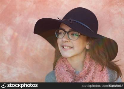Smiling preteen girl wearing pink scarf and a black hat
