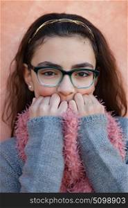 Smiling preteen girl wearing pink scarf and glasses